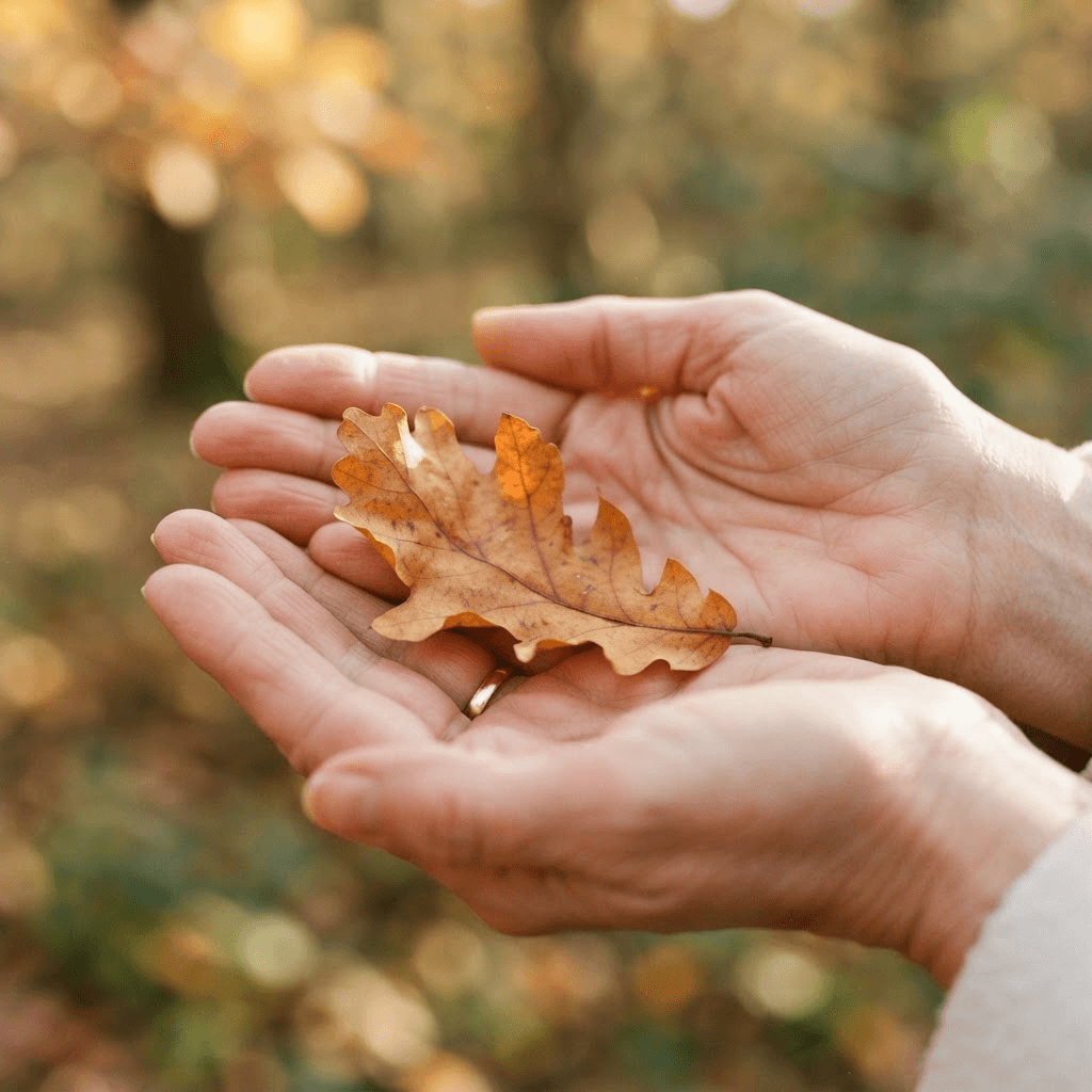 A dry autumn leaf resting gently in open hands