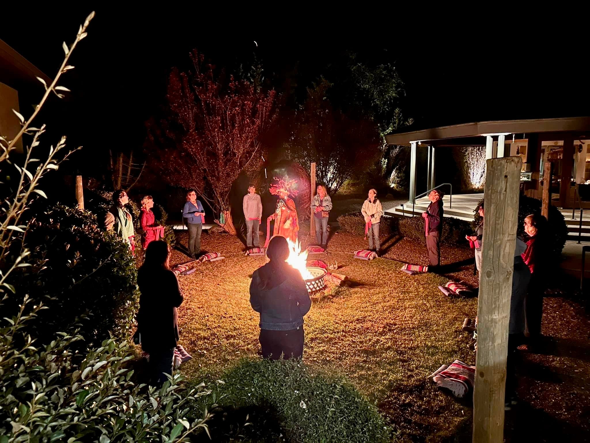 Guests gathered in a circle around a fire pit for an evening ceremony beneath the stars at Sedonya