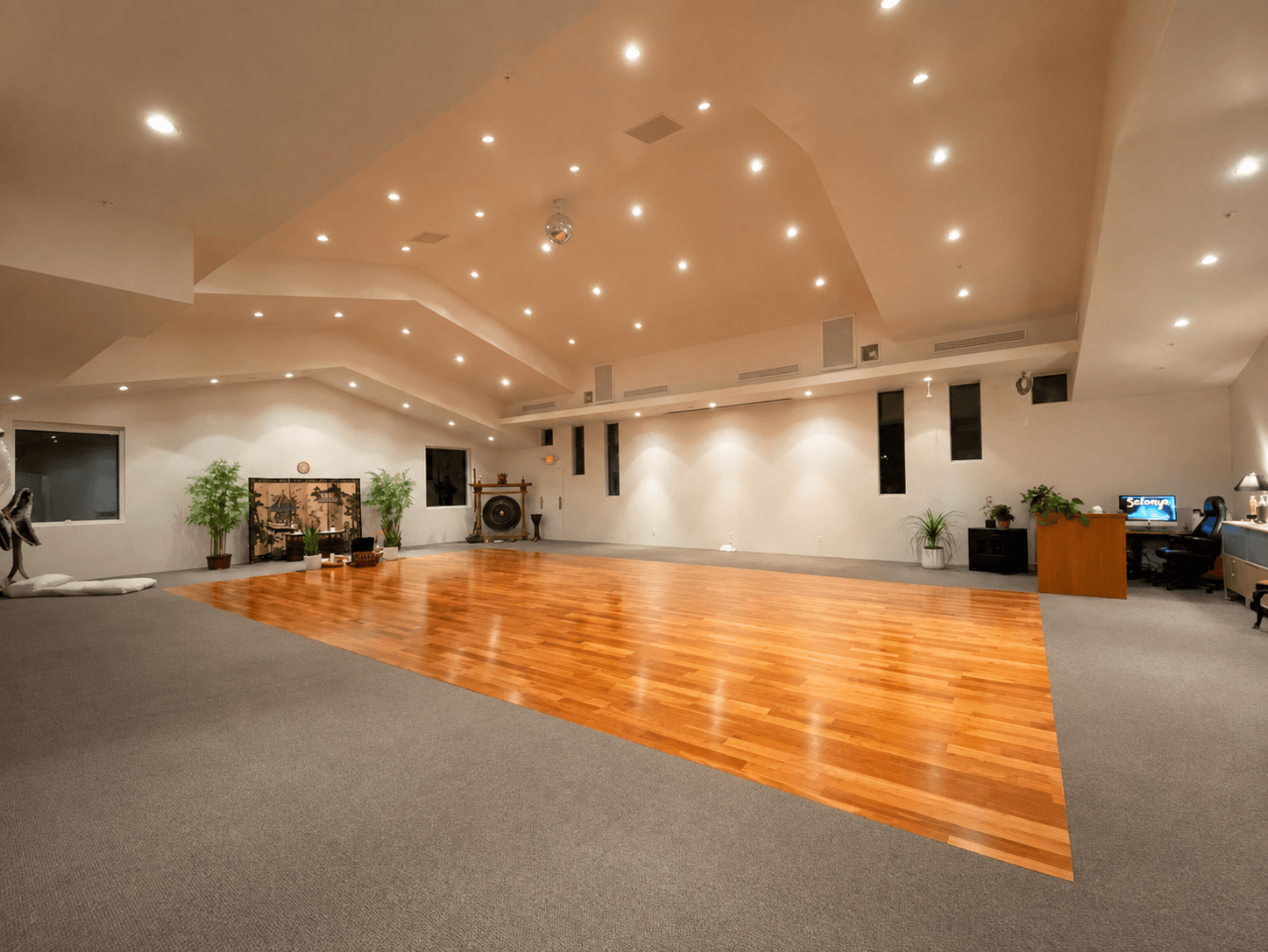 The Cathedral's empty hardwood floor and vaulted ceiling, with the gong, screen and desk visible along the far wall