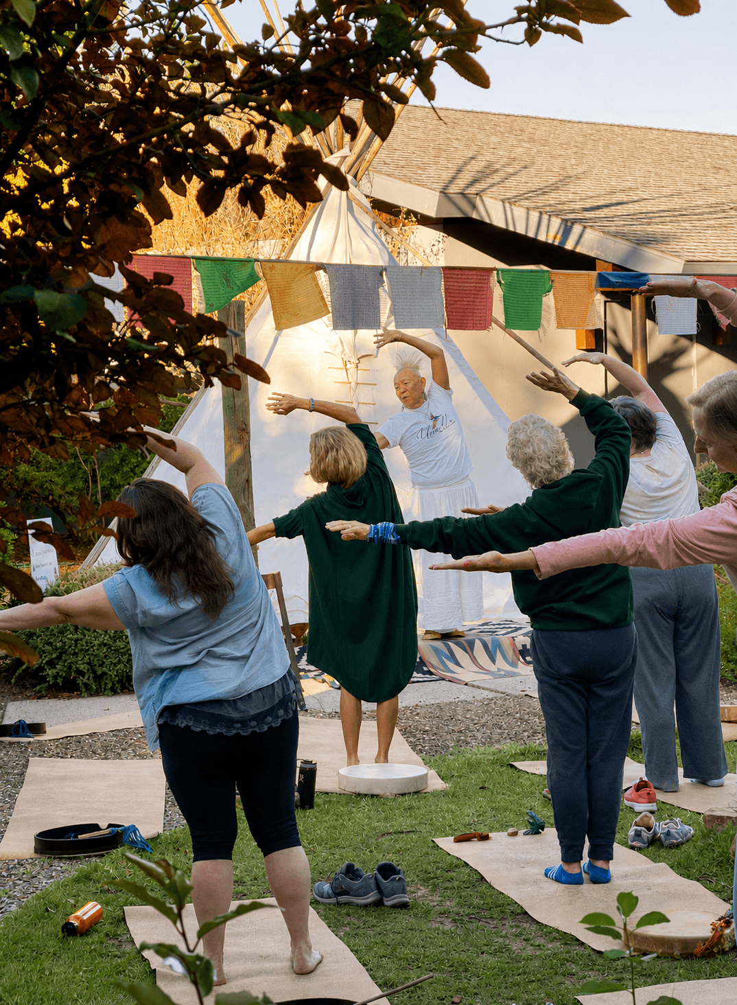 A morning movement practice held outdoors near a teepee on the Sedonya grounds