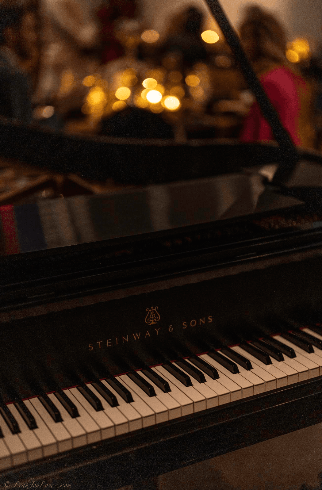 The Cathedral's grand piano, candlelight glowing in the background