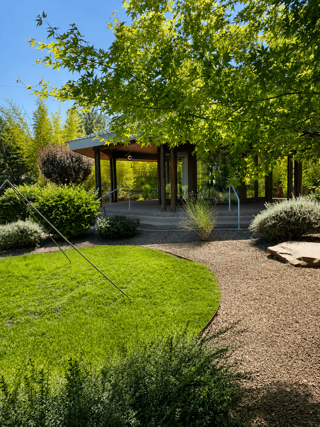 The octagonal Temple, glass-walled and glowing, tucked beneath a canopy of trees by day
