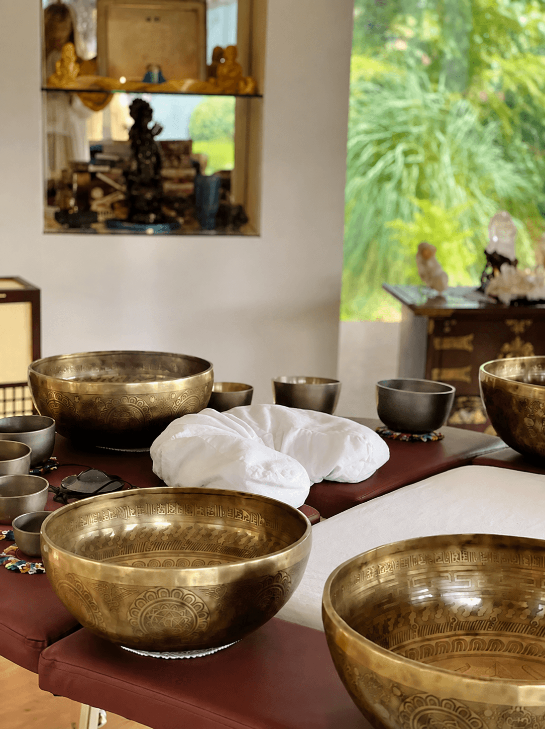 Singing bowls of every size gathered on the treatment table, a bolster waiting at its center